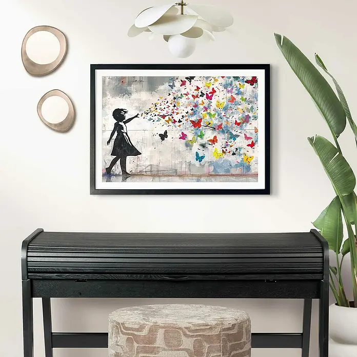 Reinders Holzrahmen - 50 x 70 cm, Schwarz - An der Wand hängt ein gerahmtes Kunstwerk eines Mädchens und bunten Schmetterlingen über einem schwarzen Schreibtisch mit Hocker.
