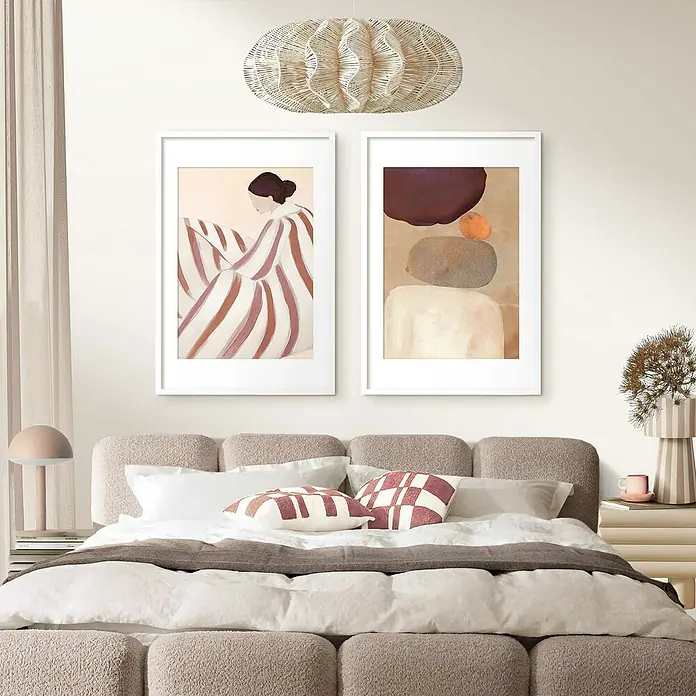 Reinders Holzrahmen - 61 x 91,5 cm, Weiß - Schlafzimmer-Interieur mit zwei gerahmten Kunstwerken über einem mit Kissen geschmückten Bett. Der Raum wird von einer dekorativen Lampe erhellt.