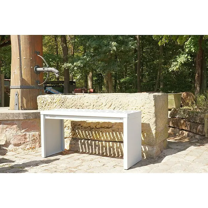 Palatino Gartenbank Bridge - B x T x H: 109 x 40 x 54 cm, Stahl, Weißaluminium - Der Fokus liegt auf einer modernen, weißen Bank, die vor einer rustikalen Steinmauer im Freien platziert ist. Die Bank bietet eine schlichte Sitzgelegenheit.