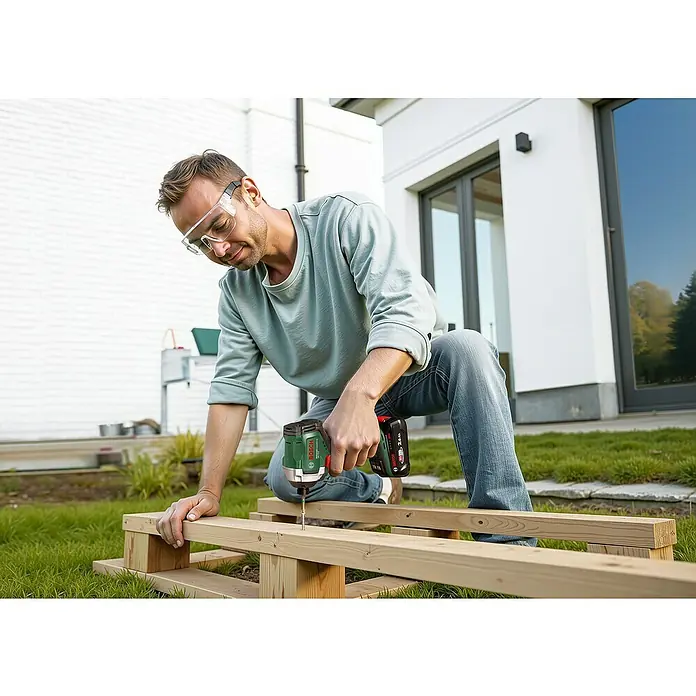 Bosch Power for All 18V Akku-Drehschlagschrauber UniversalImpactDrive 18V-210 - 18 V, Ohne Akku, 210 Nm - Mann arbeitet mit einem Bosch Akku-Schlagschrauber an einem Holzprojekt im Freien, mit Schutzbrille für Sicherheit.
