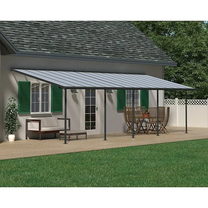 Palram – Canopia Terrassenüberdachung Sierra - B x T: 924 x 299 cm, Anthrazitgrau, Polycarbonat, Klar - Außenaufnahme einer grauen Terrassenüberdachung, die Schutz und Schatten für Sitzmöbel und einen Essbereich bietet.