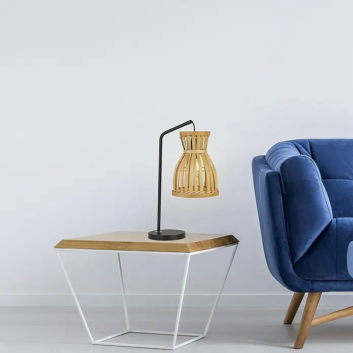 Searchlight Tischleuchte Malaga - 60 W, L x B x H: 26 x 17 x 45 cm, E14 - Tischleuchte mit Schirm aus hellem Holz auf einem Beistelltisch mit weißem Metallgestell neben einem blauen Samtsessel.