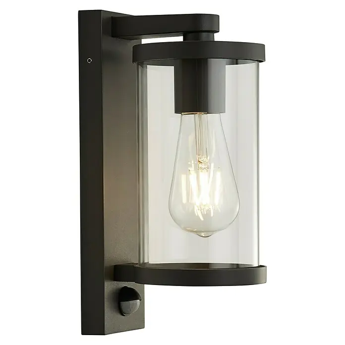 Searchlight Sensor-Außenleuchte Bakerloo - 60 W, 16 x 12 x 29 cm, Schwarz, IP44 - Nahaufnahme einer modernen Wandleuchte mit einem klaren, zylindrischen Glasgehäuse und einer Edison-Glühbirne.
