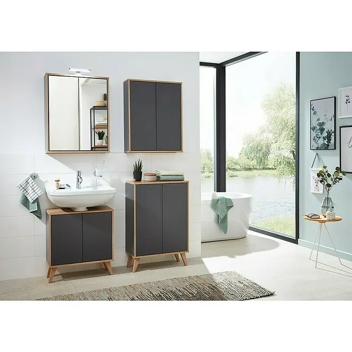 Fackelmann Finn Bad-Midischrank - B x T x H: 600 x 305 x 750 mm, Ast-Eiche, Anthrazit - Badezimmer-Interieur mit einem Waschtischunterschrank in Grau- und Holzoptik, einem Hängeschrank und Spiegel. Eine Badewanne steht am Fenster.
