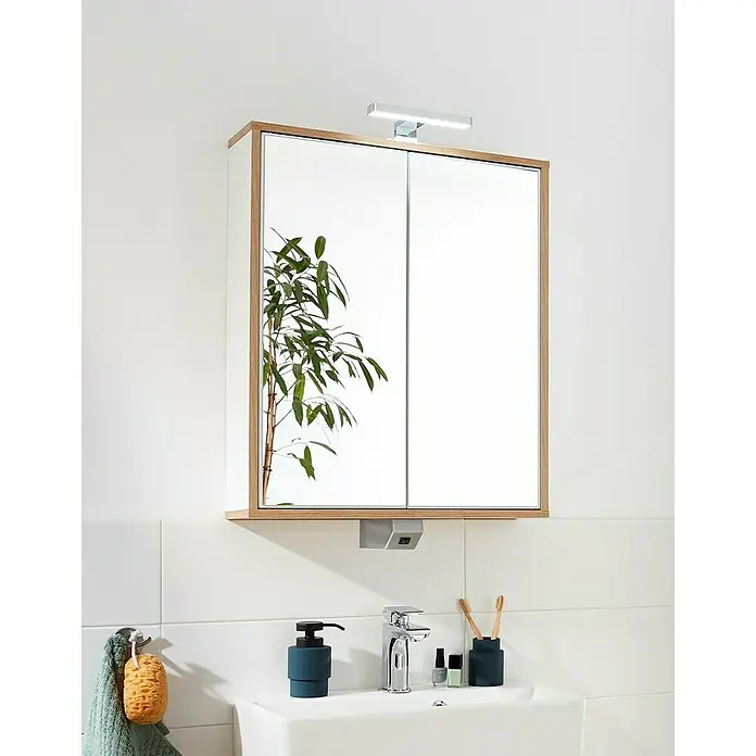 Fackelmann Finn Spiegelschrank - B x H: 600 x 750 mm, Ast-Eiche, Weiß - Ein Badezimmerschrank mit Spiegeltüren, einer Holzumrandung und einer Lampe darüber, montiert über einem Waschbecken.