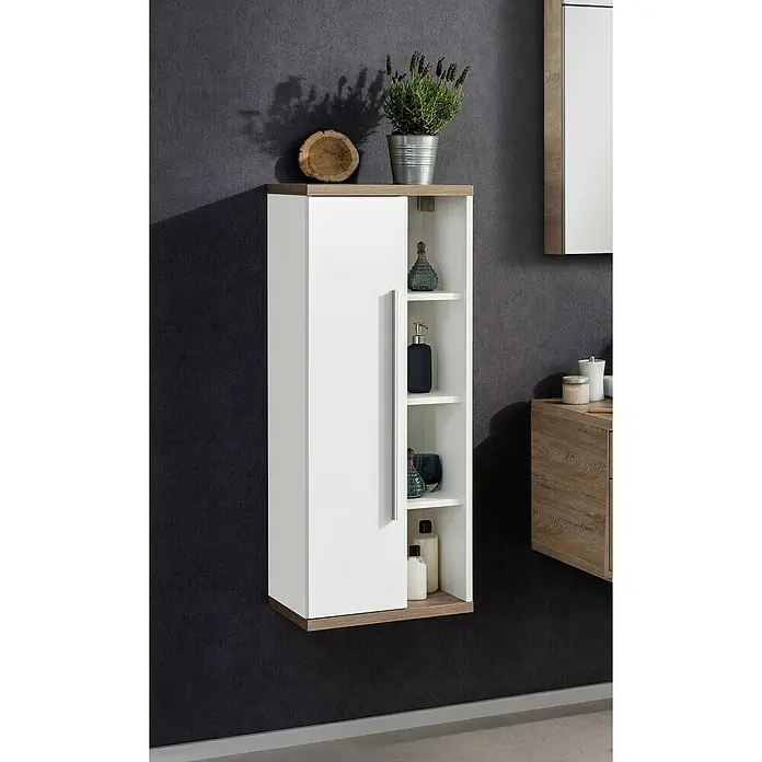 Fackelmann Stanford Bad-Midischrank - B x T x H: 418 x 320 x 1.060 mm, Nature Oak, Weiß, Anschlag: links - Ein schmaler weißer Hängeschrank mit Holzakzenten, der mit dekorativen Gegenständen und Badartikeln auf den Regalen geschmückt ist.