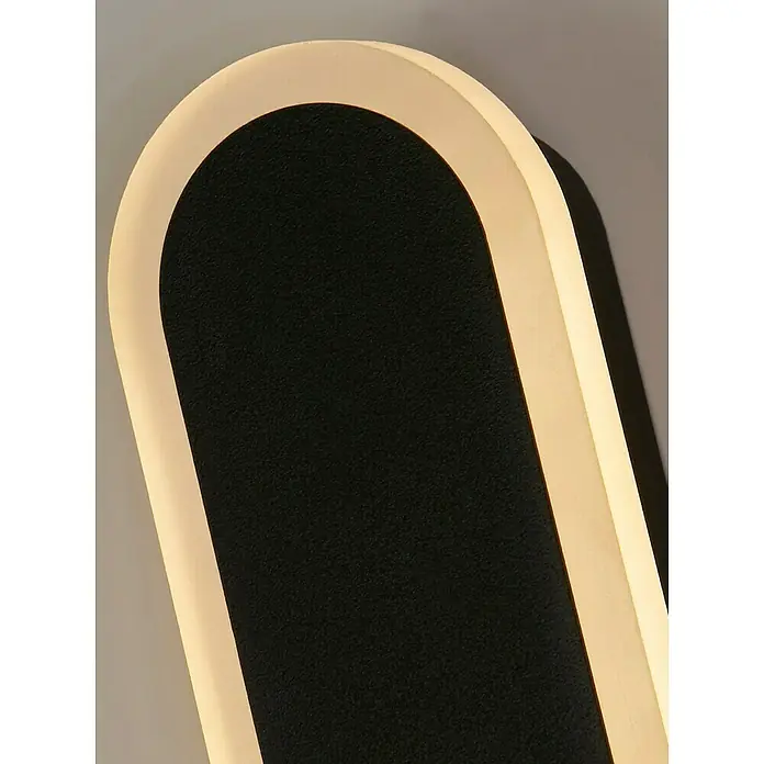 Searchlight LED-Außenwandleuchte Bordo - 12 W, 8 x 8 x 60 cm, IP65 - Nahaufnahme einer länglichen, gerundeten Wandleuchte mit einem schwarzen Hintergrund und einer warmen, gelblichen Beleuchtung.