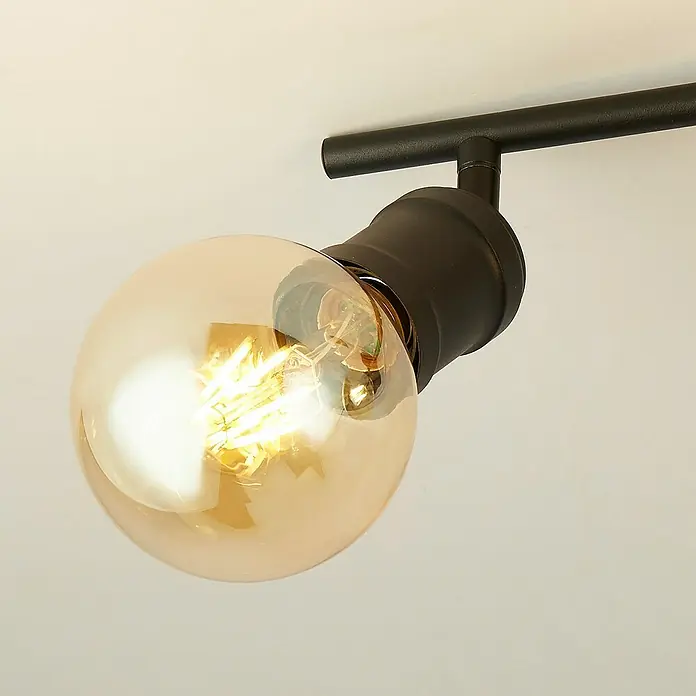 Searchlight Deckenstrahler Dance - 60 W, L x B x H: 79 x 8 x 16 cm, Schwarz, E27 - Nahaufnahme einer stilvollen Deckenleuchte mit einer bernsteinfarbenen Edison-Glühbirne und einer schwarzen Halterung.