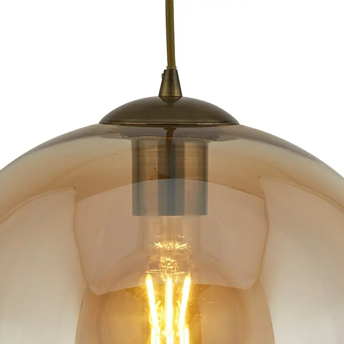 Searchlight Pendelleuchte Balls - 60 W, L x B x H: 25 x 25 x 33 cm, Amber, Messing, E27 - Nahaufnahme einer goldenen Hängelampe mit sichtbarer Glühbirne, die ein warmes Licht ausstrahlt und für eine gemütliche Atmosphäre sorgt.