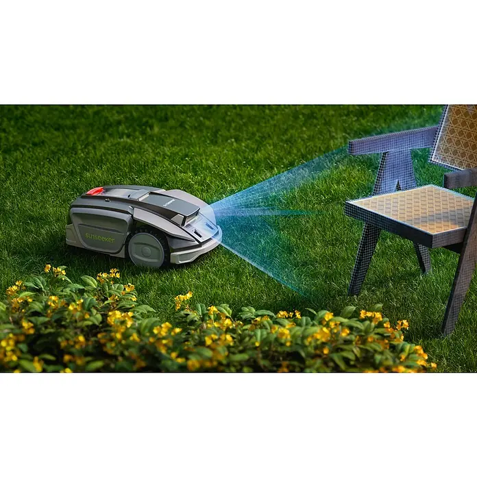 Sunseeker Mähroboter S5 - 1.600 m², Schnittbreite: 20 cm, Kamera-gestützte Navigation, RTK - Der Sunseeker Mähroboter mit blauen Sensoren manövriert auf einem Rasen mit gelben Blumen und Gartenstühlen.