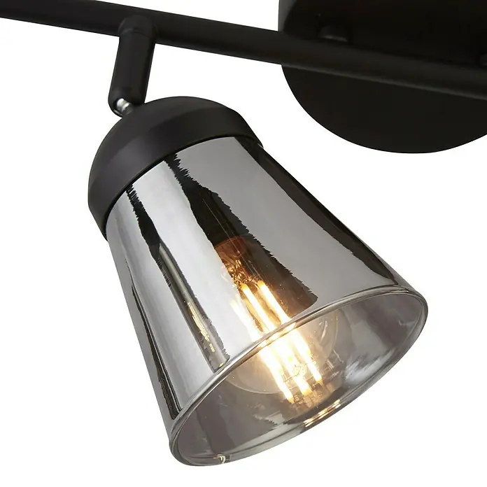 Searchlight Deckenstrahler Mega - 40 W, L x B x H: 83 x 24 x 16 cm, Schwarz/ Rauchglas, E14 - Nahaufnahme einer modernen schwarzen Schienenleuchte mit einem reflektierenden, getönten Glasschirm und einer warm leuchtenden Glühbirne.