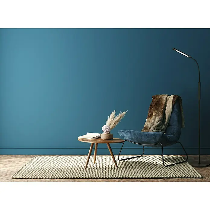 Searchlight LED-Stehleuchte Plume - 5 W, Höhe: 160 cm, Schwarz - Wohnzimmer-Interieur mit einem bequemen Sessel mit Überwurf, einem Beistelltisch mit Deko und einer Stehlampe, die eine gemütliche Atmosphäre schaffen.