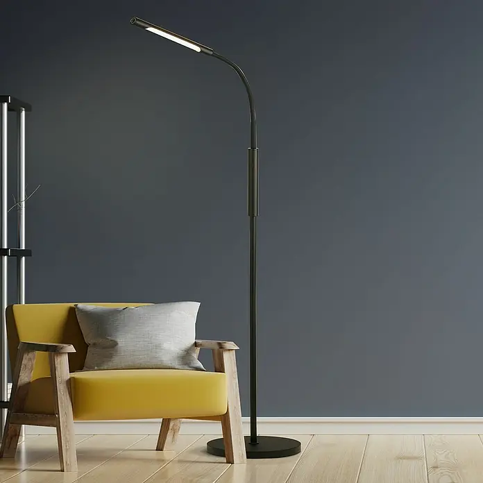 Searchlight LED-Stehleuchte Plume - 5 W, Höhe: 160 cm, Schwarz - Elegante Stehlampe mit schlankem, schwarzem Design und warmem Licht, perfekt für eine gemütliche Leseecke mit gelbem Sessel und grauem Kissen.