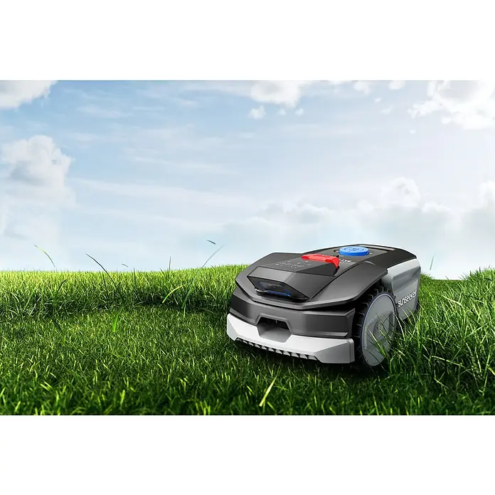 Sunseeker Mähroboter-Set V1 inkl. Garage - 300 m², Schnittbreite: 16 cm, Kamera-gestützte Navigation - Ein Sunseeker Rasenmähroboter mäht den Rasen unter blauem Himmel. Das futuristische Design und die präzise Mähleistung machen ihn zum Gartenhelfer.