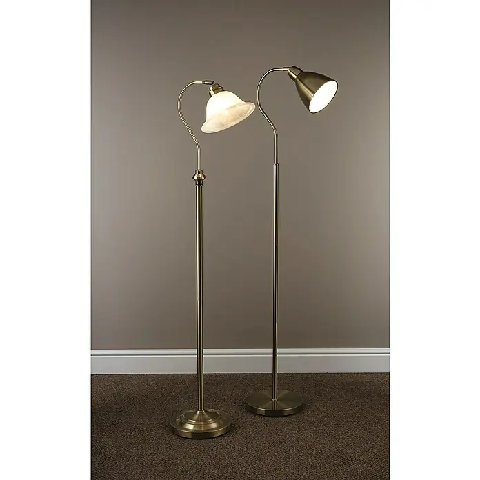 Searchlight Stehleuchte Scavo - 60 W, Höhe: 140 cm, Messing, E27 - Zwei Stehlampen in Messingoptik. Eine Lampe hat einen Glasschirm, die andere einen Metallschirm. Beide Lampen spenden warmes Licht und stehen auf Teppich.