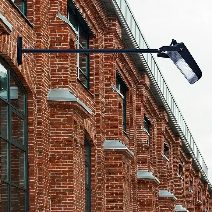 Searchlight LED-Außenwandleuchte Pub - 9 W, 85,5 x 14 x 5 cm, Schwarz, IP65 - Eine schwarze Außenleuchte ist an einer Backsteinfassade montiert und spendet helles Licht für den Außenbereich.