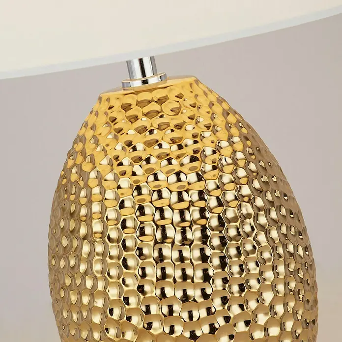 Searchlight Tischleuchte Nadine - L x B x H: 28 x 28 x 45 cm, Gold, Beige - Nahaufnahme einer goldenen Tischlampe mit gehämmerter Textur und weißem Lampenschirm, die ein elegantes und warmes Ambiente ausstrahlt.