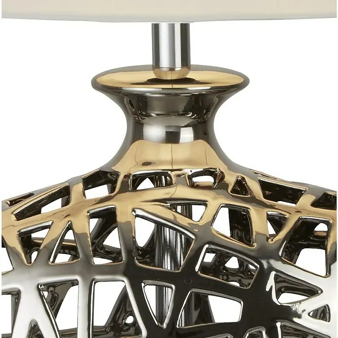 Searchlight Tischleuchte Network - 60 W, L x B x H: 36 x 20 x 56 cm, Chrom, Weiß, E27 - Nahaufnahme einer Tischlampe mit einem kunstvollen, durchbrochenen Lampenfuß in Gold und Silber, der ein modernes Designelement darstellt.