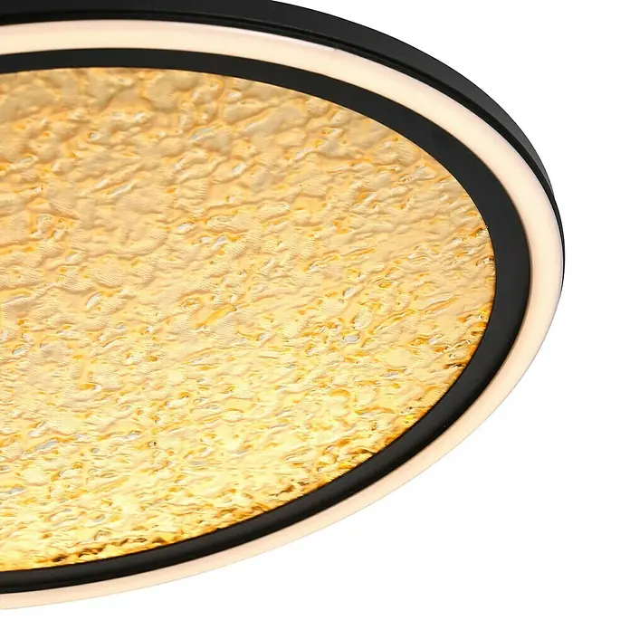 Searchlight LED-Deckenleuchte rund Luna - 32 W, Ø x H: 39,5 x 6 cm, Schwarz/ Gold, Warmweiß - Nahaufnahme einer stilvollen Deckenleuchte mit einem goldenen, strukturierten Diffusor und einem modernen, schwarzen Rahmen mit LED-Akzenten.