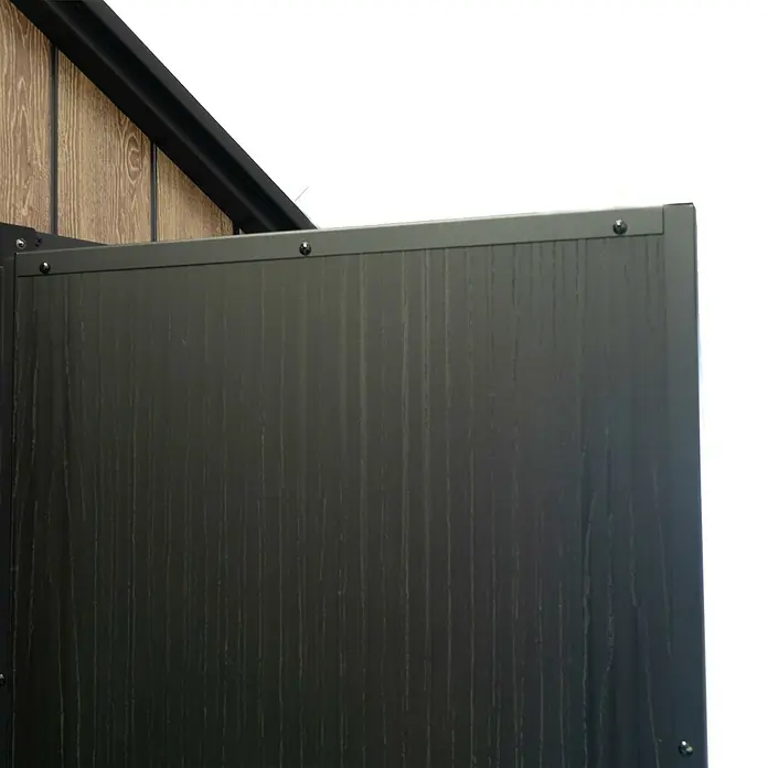 Hoggar Gartenhaus Oak - Außenmaß inkl. Dachüberstand (B x T): 223 x 222 cm, Kunststoff, Braun, 5,02 m² - Nahaufnahme eines Elements aus Holzverbundmaterial mit einer markanten schwarzen Beschichtung und sichtbaren Befestigungselementen.