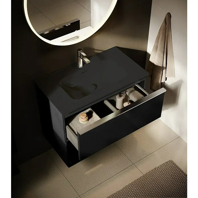 Riva Moon Waschtischunterschrank - B x T x H: 80 x 45,3 x 63,5 cm, Schwarz - Elegantes, schwarzes Waschbecken mit geöffneter Schublade, die Handtücher und Pflegeprodukte zeigt, unter einem runden Spiegel mit Beleuchtung.