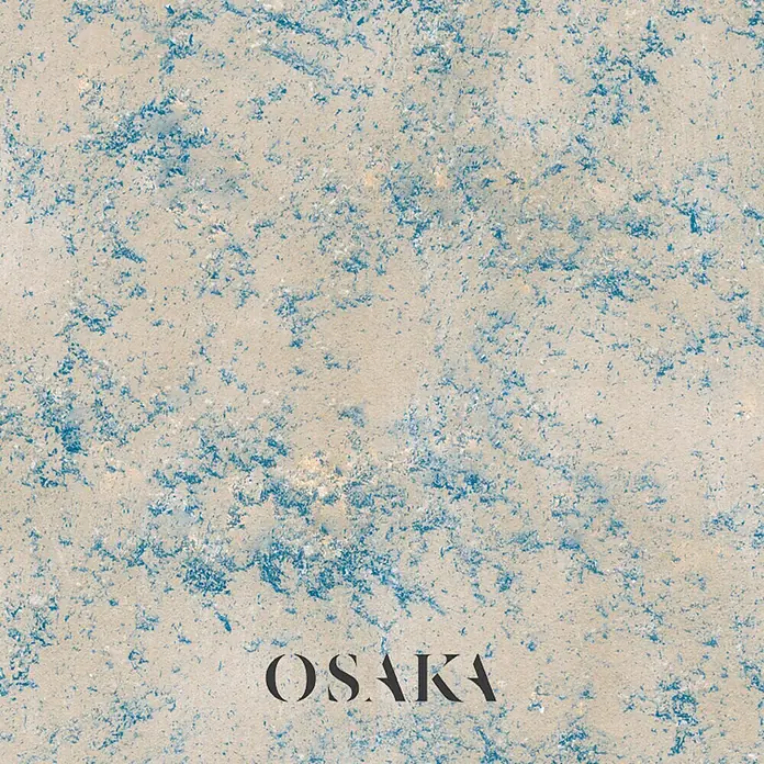 Osaka Yeso con efecto de color Madreperla - Azul, Brillante - Un cuarzo color crema con delicadas motas azules, añadiendo un toque de tranquilidad y elegancia al espacio. Ideal para encimeras o pavimentos.