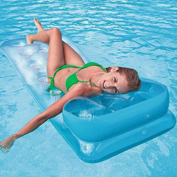 Intex Colchoneta hinchable 18 Vasos - Plástico - Mujer relajándose en una tumbona inflable azul con reposacabezas y portavasos en el agua.
