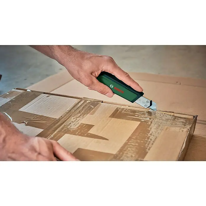 Bosch Cuttermesser - Klingenbreite: 18 mm, Abbrechklinge - Ein grünes Bosch-Messer schneidet durch das Klebeband auf einem Karton. Hervorhebung der Präzision und Funktionalität.