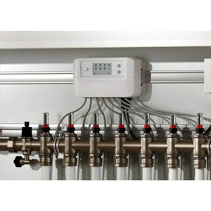 Homematic IP Fußbodenheizungsregler HmIP-FALMOT-C8 - 135 x 52 x 85 mm - Nahaufnahme einer Heizungsanlage mit Steuerungseinheit und mehreren Durchflussmessern für ein effizientes Heizsystem.