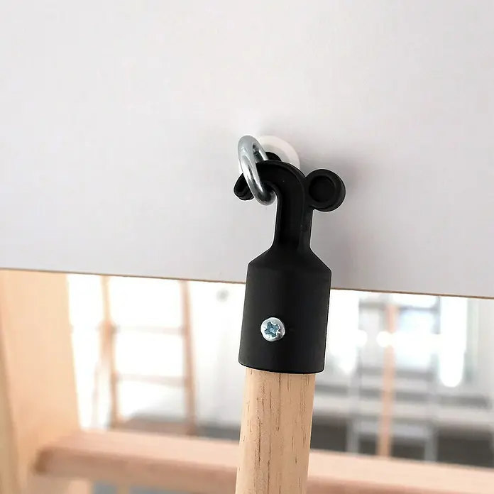 Dolle Griffstange - Passend für: Dolle Bodentreppen Pur, Easy Loft, Easy Loft Pro, Kompakt, Isotrend, Mini - Nahaufnahme einer schwarzen Schaukelbefestigung an einem Holzstab, die an einer weißen Oberfläche befestigt ist.
