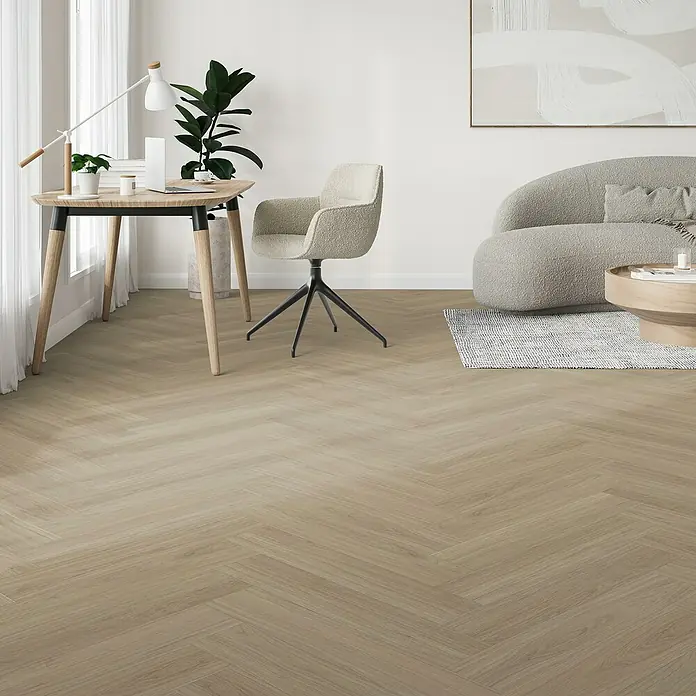 Parador Vinylboden Trendtime 3 - Eiche Oxford geschliffen, Fischgrät, 730 x 146 x 5 mm - Elegantes Interieur mit hellem Fischgrätparkett. Bürotisch, Stuhl und Sofa schaffen eine stilvolle und wohnliche Atmosphäre im Raum.