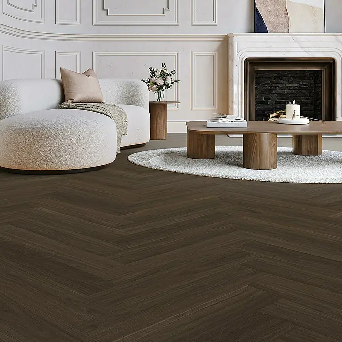 Parador Vinylboden Trendtime 3 - Eiche Oxford dunkelbraun, Fischgrät, 730 x 146 x 5 mm - Elegantes Wohnzimmer mit dunklem Fischgrätparkettboden, das dem Raum Wärme und Struktur verleiht.