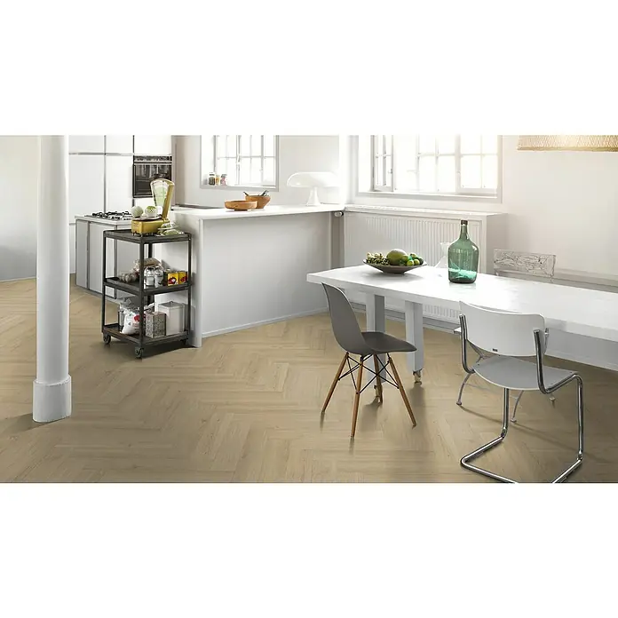 Parador Vinylboden Trendtime 3 - Eiche Regent beige, Fischgrät, 730 x 146 x 5 mm - Heller Raum mit einem Esstisch, Stühlen und einem Rollwagen mit Lebensmitteln. Das Parkett im Fischgrätmuster verleiht dem Raum eine elegante Note.