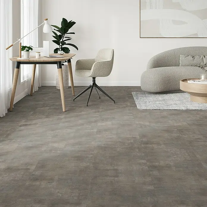 Parador Vinylboden Basic 5.3 - Mineral Grey, Fliese, 914 x 457 x 5,3 mm - Helle Büroeinrichtung mit modernem Schreibtisch, Drehstuhl und stilvollem Vinylboden in Grau, der dem Raum eine zeitgemäße Atmosphäre verleiht.