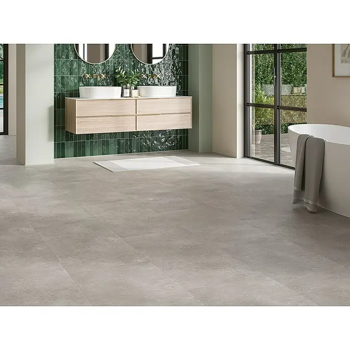 Parador Vinylboden Basic 5.3 - Stein Trafalgar hellgrau, Fliese, 914 x 457 x 5,3 mm - Helles Badezimmer mit modernem Doppelwaschtisch, grauen Fliesen und grüner Wandverkleidung für ein entspannendes Ambiente.