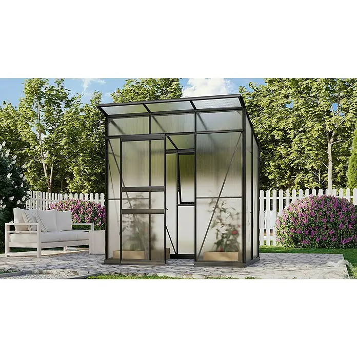 Vitavia Gewächshaus Fokus Kunststoff - Schwarz, Außenmaß inkl. Dachüberstand (B x T): 1.672 x 1.958 cm, Material Seitenwand: Kunststoff - Eine Nahaufnahme eines Gewächshauses mit Pflanzen im Inneren, umgeben von üppigem Grün und einem gemütlichen Gartenbereich mit Couch.