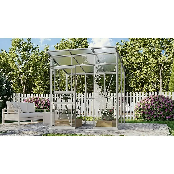 Vitavia Gewächshaus Fokus Glas - Material Seitenwand: Glas, Außenmaß inkl. Dachüberstand (B x T): 1.672 x 1.958 cm, Aluminium - Ein geräumiges Gewächshaus aus Glas und Metall im Garten mit Blumen, einem Zaun und einer Couch für entspannte Stunden.