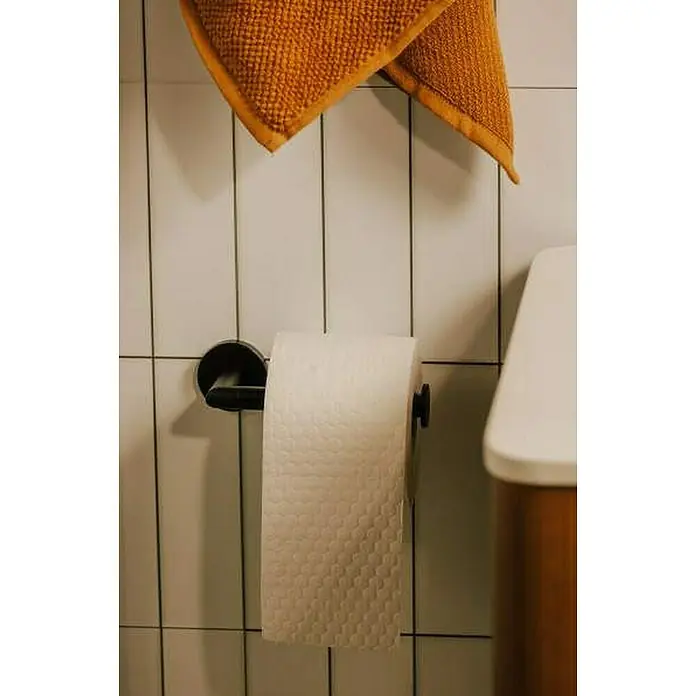 Cosmic Portarrollos Dual Start - Sin tapa, Negro - Una escena de baño con una toalla naranja colgando y un rollo de papel higiénico, mostrando una configuración de baño elegante.