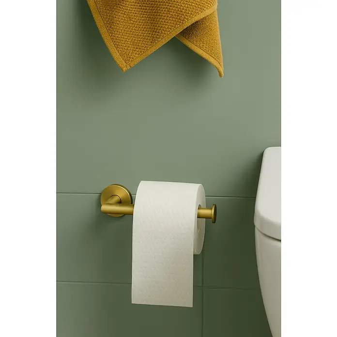 Cosmic Portarrollos Dual Start - Sin tapa, Oro - Un primer plano de un portarrollos de papel higiénico dorado con un rollo de papel, junto a un inodoro y una toalla amarilla en una pared verde.