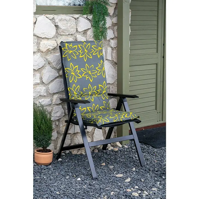 beo Gartenmöbel-Auflage Bonn - Hochlehner, 6 Stk., L x B x H: 118 x 50 x 6 cm, Schwarz/Gelb - Ein Gartenstuhl mit grauem Kissen mit gelben Blumen steht vor einer Steinmauer und einer grünen Tür. Das Kissen ist ein Hingucker.