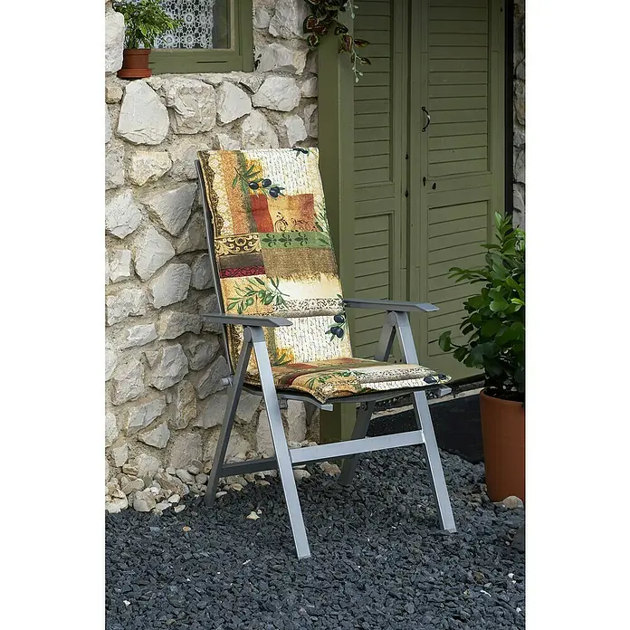 beo Gartenmöbel-Auflage Glasgow - Niederlehner, 4 Stk., L x B x H: 120 x 48 x 5 cm, Baumwolle, Polyester, Braun/Grün - Bequemer Gartenstuhl mit Olivenmuster-Kissen vor einer Steinmauer und grünen Fensterläden. Der Stuhl lädt zum Entspannen im Freien ein.