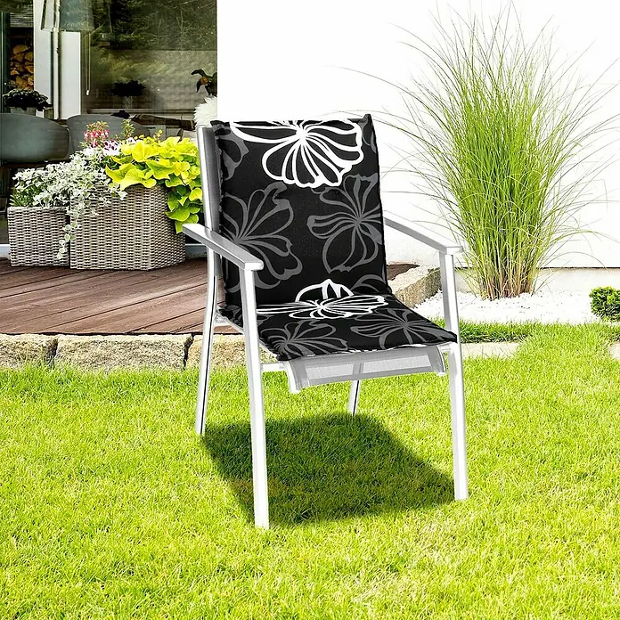 beo Gartenmöbel-Auflage Barcelona - Niederlehner, 6 Stk., L x B x H: 101 x 50 x 6 cm, Baumwolle, Polyester, Schwarz/Weiß - Ein Gartenstuhl mit einem schwarzen Sitzkissen mit Blumenmuster auf einem saftig grünen Rasen im Freien.