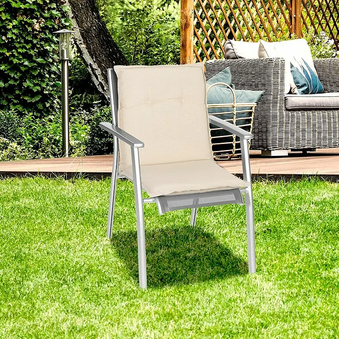 beo Gartenmöbel-Auflage Takume - Niederlehner, 4 Stk., L x B x H: 98 x 46 x 8 cm, Baumwolle, Polyester, Beige - Ein silberfarbener Gartenstuhl mit cremefarbener Polsterung steht auf einem grünen Rasen. Er bietet Komfort und Stil für entspannte Stunden im Freien.