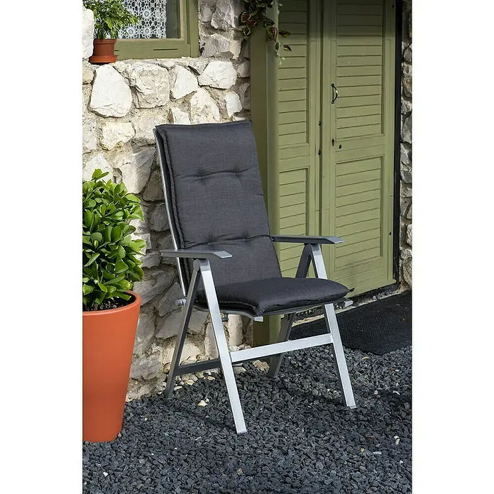 beo Gartenmöbel-Auflage Belsh - Hochlehner, 4 Stk., L x B x H: 118 x 50 x 6 cm, Baumwolle, Polyester, Grau - Elegantes Bild eines grauen Outdoor-Stuhls mit silbernem Rahmen vor einer rustikalen Steinwand und grünen Türen.