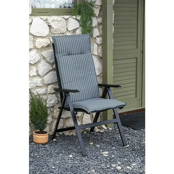 beo Gartenmöbel-Auflage Belm - Hochlehner, 6 Stk., L x B x H: 118 x 50 x 6 cm, Baumwolle, Polyester, Grau/Weiß - Ein grauer, hochlehniger Gartenstuhl mit gestreifter Polsterung steht vor einer Steinmauer und einer grünen Holztür.