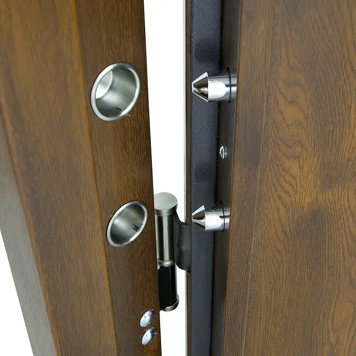 SegureStil Puerta de entrada exterior VH500 Serie V - 90 x 207 cm, Derecha, Nogal, Acorazada - Detalle de una puerta de madera abierta con herrajes plateados y cerradura de seguridad, destacando su construcción robusta y diseño.