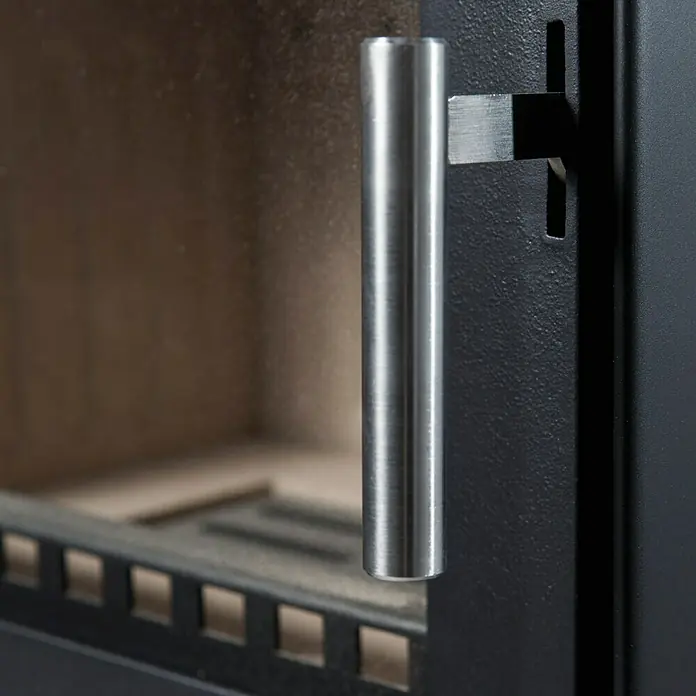 Aduro Kaminofen 14 - 6,5 kW, Raumheizvermögen: 334 m³, Material Verkleidung: Stahl, Schwarz - Detailaufnahme eines Ofens mit Fokus auf dem silbernen Griff und der schwarzen Metalltür. Das Glas der Tür gibt den Blick ins Innere frei.