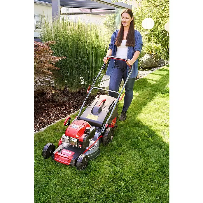 AL-KO Benzin-Rasenmäher Easy 4.66 P-D - 1,9 kW, 131 cm³, Schnittbreite: 46 cm - Eine Frau mäht den Rasen mit einem AL-KO Benzin-Rasenmäher 4.66 P-A Edition für einen gepflegten Garten.