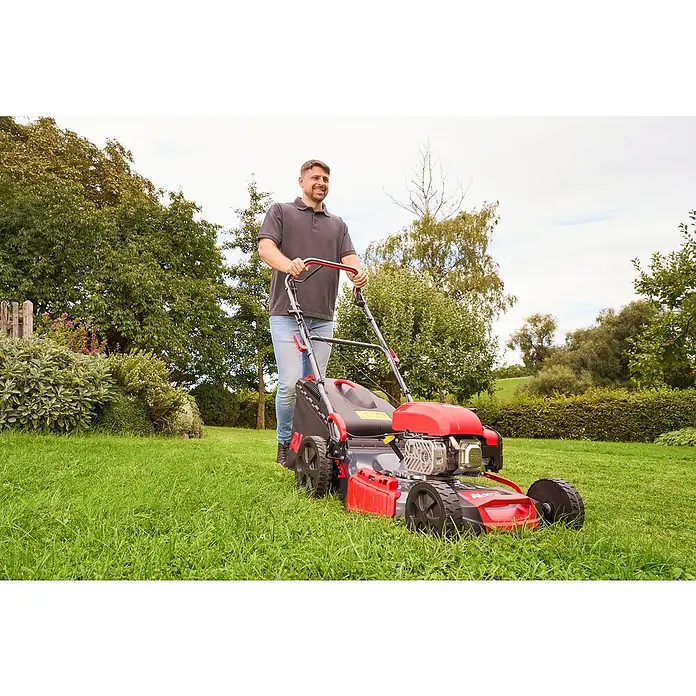AL-KO Benzin-Rasenmäher Easy 5.16 SP-D - 2,6 kW, 171 cm³, Schnittbreite: 51 cm - Ein Mann schiebt einen roten AL-KO Rasenmäher über einen grünen Rasen. Der Rasenmäher ist das Hauptobjekt im Bild.