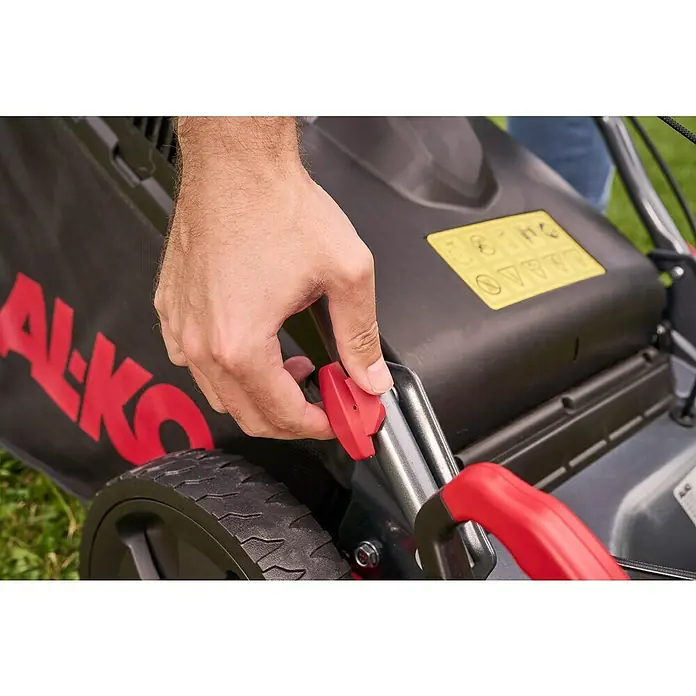 AL-KO Benzin-Rasenmäher Easy 4.16 P-D - 1,2 kW, 79,8 cm³, Schnittbreite: 41 cm - Nahaufnahme einer Hand, die einen roten Hebel an einem AL-KO Rasenmäher betätigt, um die Schnitthöhe einzustellen.